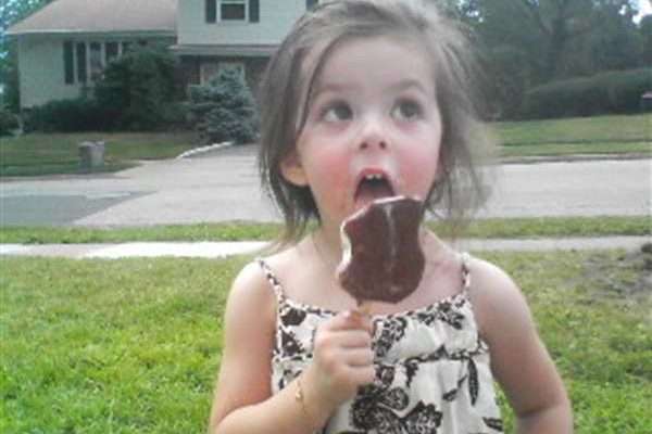 Little Girl is Licking a Chocolate Ice Cream