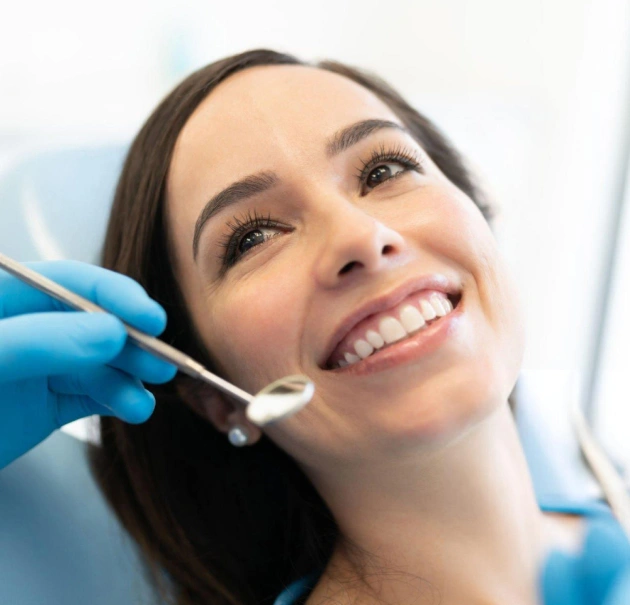 Dental professional examining patient's teeth during routine checkup in clinical setting.
